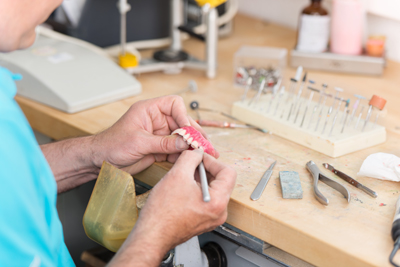 Dental Technician's Hands Working On Teeth Model